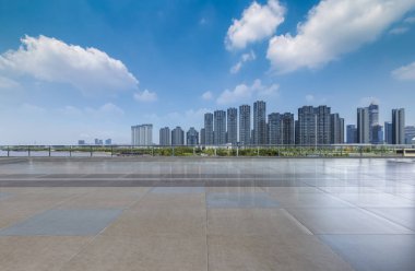 Panoramik siluet ve boş yolu, boş beton zemini olan modern iş binaları.