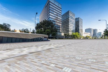 Panoramik siluet ve boş yolu, boş beton zemini olan modern iş binaları.