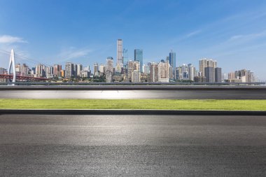 Panoramik siluet ve boş yolu, boş beton zemini olan modern iş binaları.