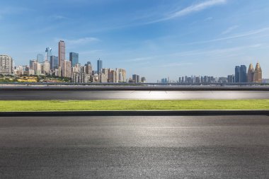 Panoramik siluet ve boş yolu, boş beton zemini olan modern iş binaları.