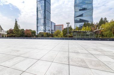 Panoramik siluet ve boş yolu, boş beton zemini olan modern iş binaları.