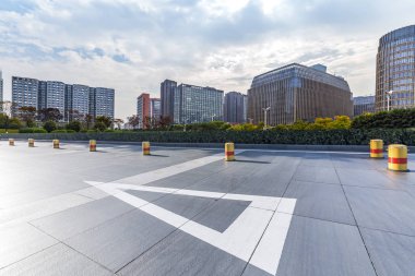 Panoramik siluet ve boş yolu, boş beton zemini olan modern iş binaları.
