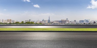 Panoramik siluet ve boş yolu, boş beton zemini olan modern iş binaları.