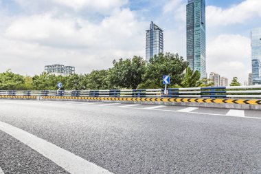 Panoramik siluet ve boş yolu, boş beton zemini olan modern iş binaları.
