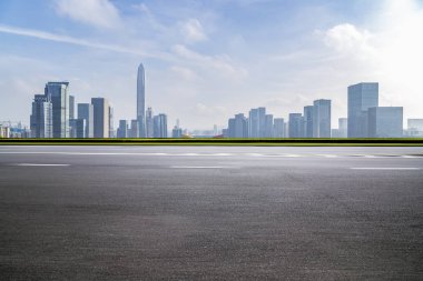 Panoramik siluet ve boş yolu, boş beton zemini olan modern iş binaları.
