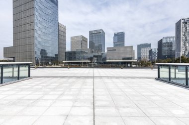 Panoramik siluet ve boş yolu, boş beton zemini olan modern iş binaları.