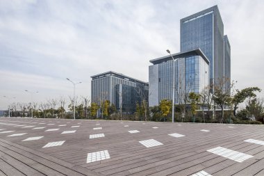 Panoramik siluet ve boş yolu, boş beton zemini olan modern iş binaları.