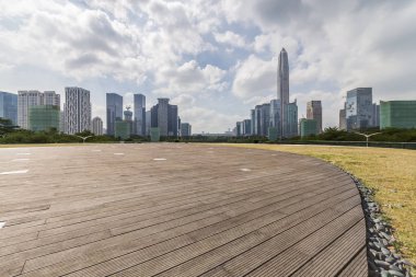 Panoramik siluet ve boş yolu, boş beton zemini olan modern iş binaları.
