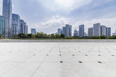 Panoramik siluet ve boş yolu, boş beton zemini olan modern iş binaları.