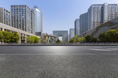 Panoramik siluet ve boş yolu, boş beton zemini olan modern iş binaları.