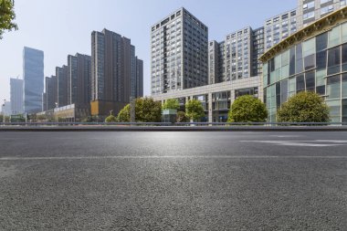 Panoramik siluet ve boş yolu, boş beton zemini olan modern iş binaları.