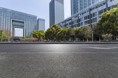 Panoramik siluet ve boş yolu, boş beton zemini olan modern iş binaları.
