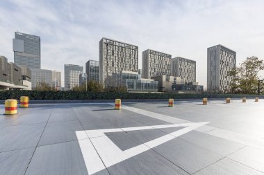 Panoramik siluet ve boş yolu, boş beton zemini olan modern iş binaları.