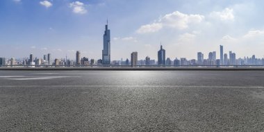Panoramik siluet ve boş yolu, boş beton zemini olan modern iş binaları.