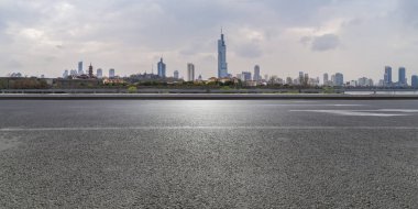 Panoramik siluet ve boş yolu, boş beton zemini olan modern iş binaları.