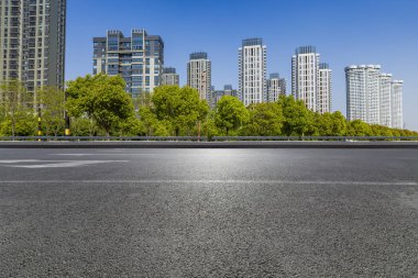 Panoramik siluet ve boş yolu, boş beton zemini olan modern iş binaları.