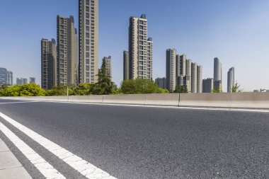 Panoramik siluet ve boş yolu, boş beton zemini olan modern iş binaları.