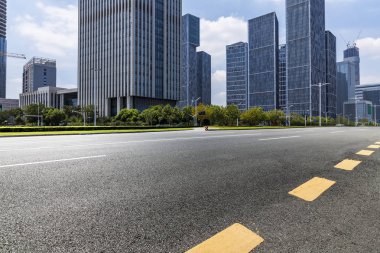 Panoramik siluet ve boş yolu, boş beton zemini olan modern iş binaları.