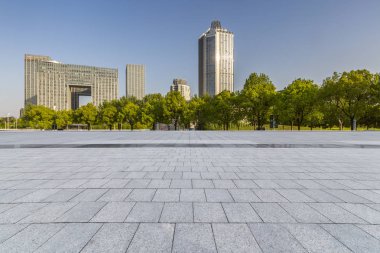 Panoramik siluet ve boş yolu, boş beton zemini olan modern iş binaları.