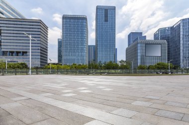 Panoramik siluet ve boş yolu, boş beton zemini olan modern iş binaları.