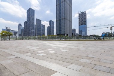 Panoramik siluet ve boş yolu, boş beton zemini olan modern iş binaları.