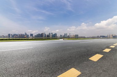 Panoramik siluet ve boş yolu, boş beton zemini olan modern iş binaları.