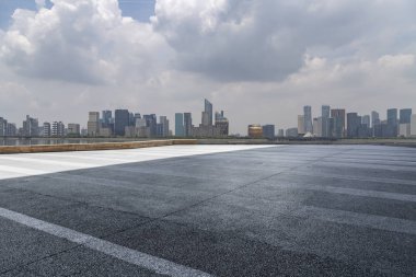 Panoramik siluet ve boş yolu, boş beton zemini olan modern iş binaları.