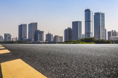 Panoramik siluet ve boş yolu, boş beton zemini olan modern iş binaları.