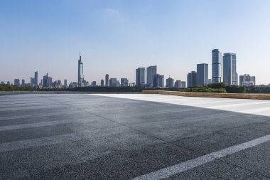 Panoramik siluet ve boş yolu, boş beton zemini olan modern iş binaları.
