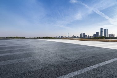 Panoramik siluet ve boş yolu, boş beton zemini olan modern iş binaları.