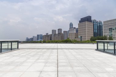 Panoramik siluet ve boş yolu, boş beton zemini olan modern iş binaları.