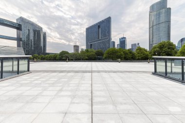 Panoramik siluet ve boş yolu, boş beton zemini olan modern iş binaları.