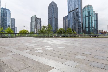 Panoramik siluet ve boş yolu, boş beton zemini olan modern iş binaları.