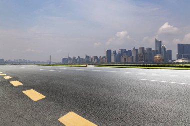 Panoramik siluet ve boş yolu, boş beton zemini olan modern iş binaları.