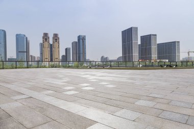 Panoramik siluet ve boş yolu, boş beton zemini olan modern iş binaları.