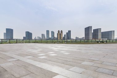 Panoramik siluet ve boş yolu, boş beton zemini olan modern iş binaları.