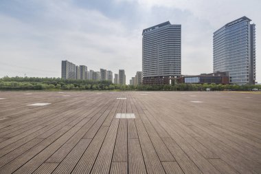 Panoramik siluet ve boş yolu, boş beton zemini olan modern iş binaları.