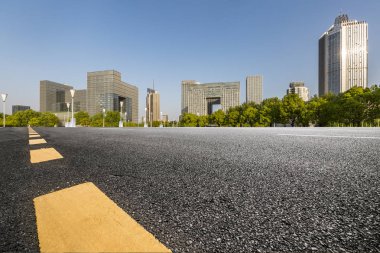 Panoramik siluet ve boş yolu, boş beton zemini olan modern iş binaları.