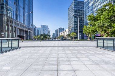 Panoramik siluet ve boş yolu, boş beton zemini olan modern iş binaları.
