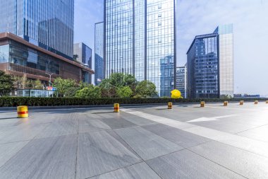 Panoramik siluet ve boş yolu, boş beton zemini olan modern iş binaları.