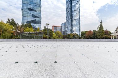 Panoramik siluet ve boş yolu, boş beton zemini olan modern iş binaları.