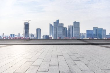 Panoramik siluet ve boş yolu, boş beton zemini olan modern iş binaları.