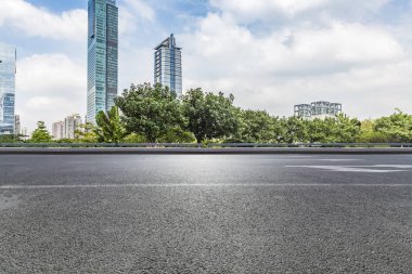 Panoramik siluet ve boş yolu, boş beton zemini olan modern iş binaları.