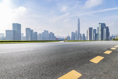 Panoramik siluet ve boş yolu, boş beton zemini olan modern iş binaları.