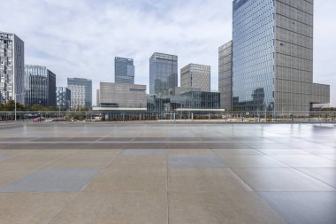 Panoramik siluet ve boş yolu, boş beton zemini olan modern iş binaları.