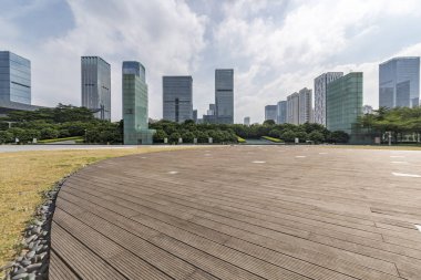Panoramik siluet ve boş yolu, boş beton zemini olan modern iş binaları.