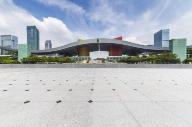 Panoramik siluet ve boş yolu, boş beton zemini olan modern iş binaları.