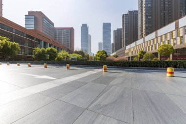 Panoramik siluet ve boş yolu, boş beton zemini olan modern iş binaları.