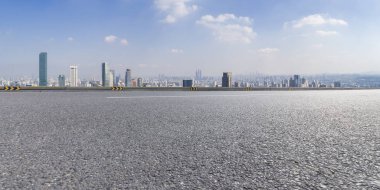 Panoramik siluet ve boş yolu, boş beton zemini olan modern iş binaları.