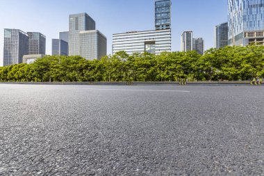 Panoramik siluet ve boş yolu, boş beton zemini olan modern iş binaları.